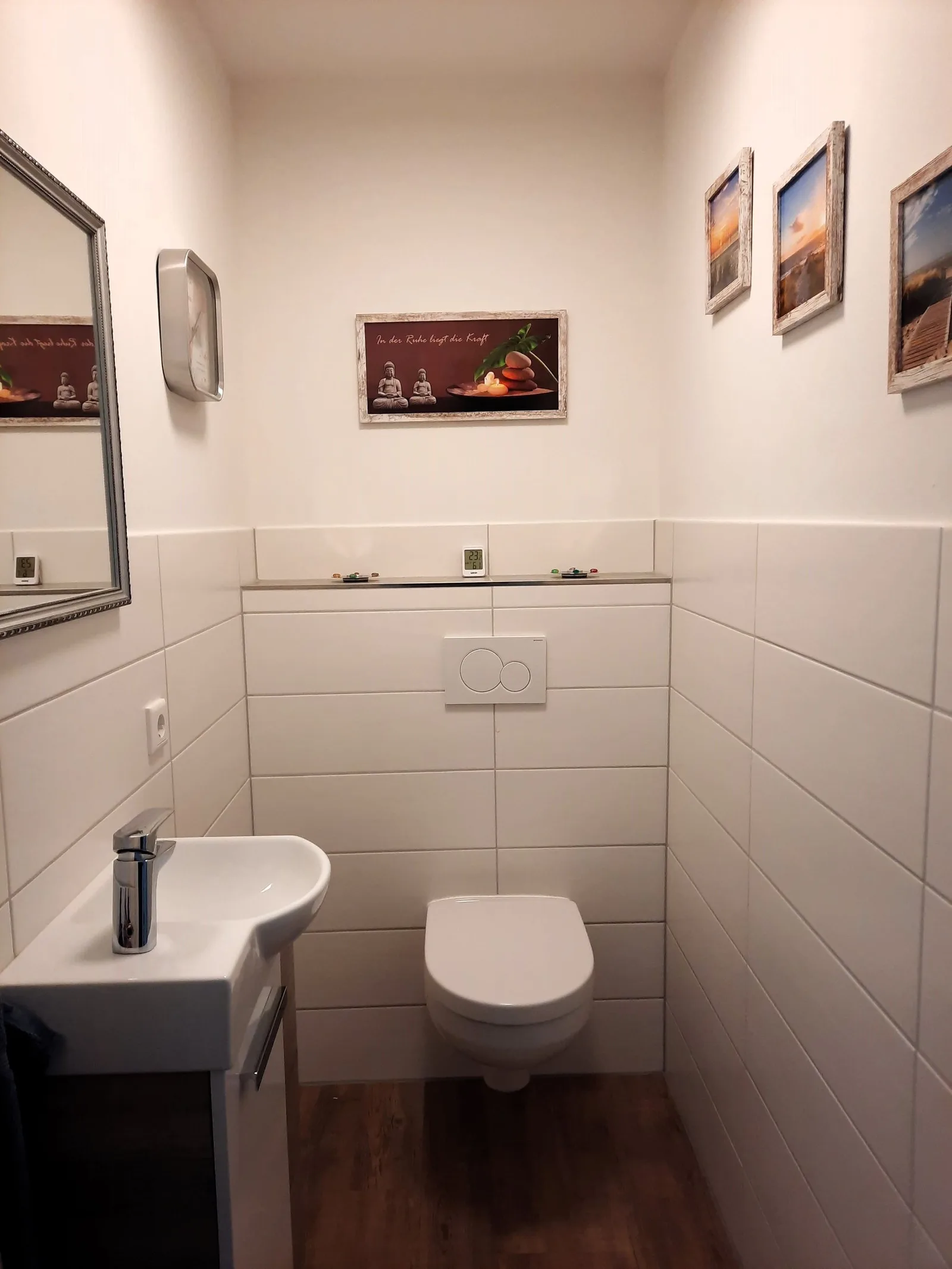 Gäste-WC mit kleinem Waschbecken und Bildern an der Wand