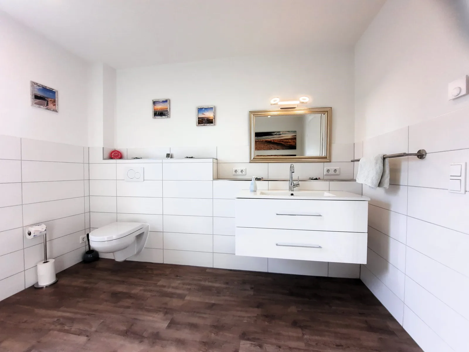 Bad mit Waschtisch, Spiegel, Wand-WC und Holzboden