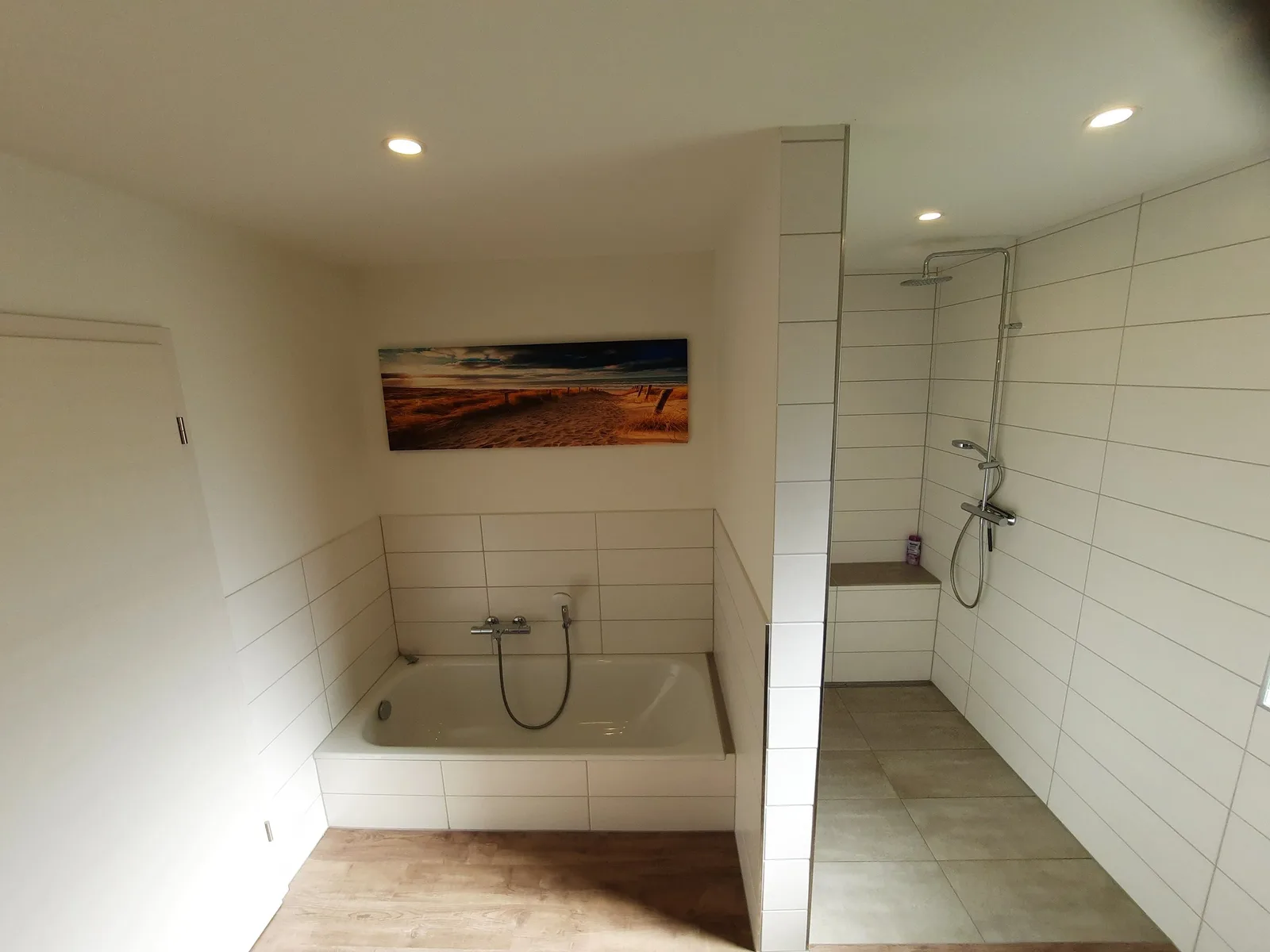 Fertiges Bad mit Wanne, gefliestem Duschbereich und Deckenspots